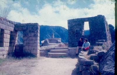 [Casal sentado entre paredes de pedras de Machu Picchu]